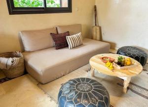 マラケシュにあるPeaceful 2BR Oasis with Pool Tennis AC - Palmeraieのソファとテーブルのあるリビングルーム