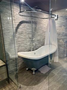 a bathroom with a bath tub and a shower at North Cottage - A Stylish Family Retreat Once Owned by Beatrix Potter in Bowness-on-Windermere +43 photos