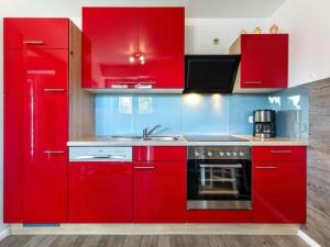 a red kitchen with red cabinets and a sink at Friederike in Tarnewitz
