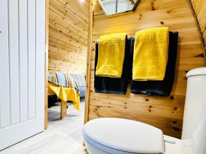 a bathroom with a toilet and yellow towels at Brora Escapes in Brora +37 photos