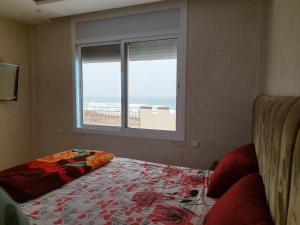 a bedroom with a bed with a view of the beach at Relaxing home in Id Taleb +1 photo