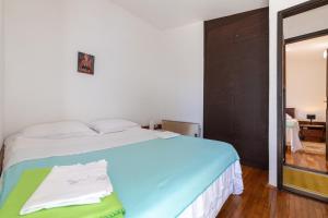 un dormitorio con una cama y un espejo en Seaside house for families with children Ivan Dolac, Hvar - 140, en Ivan Dolac