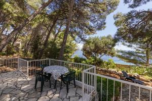 Un patio con mesa y sillas y el mar. en Seaside house for families with children Ivan Dolac, Hvar - 140, en Ivan Dolac