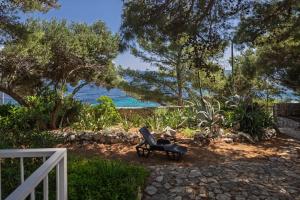 Una silla sentada en el suelo cerca del océano. en Seaside house for families with children Ivan Dolac, Hvar - 140, en Ivan Dolac 16 fotos más