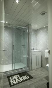 a bathroom with a glass shower with a sink and a toilet at Double story Suite in Rochdale in Rochdale