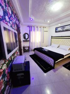 Un dormitorio con una cama y un televisor. en Chambre Meublé avec Toillette intérieure chauffe eau Wi-Fi Smart Tv, en Dakar