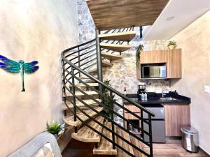 una scala a chiocciola in una cucina con una farfalla blu sul muro di Aida en ValQuirico a Santeagueda Altre 8 foto