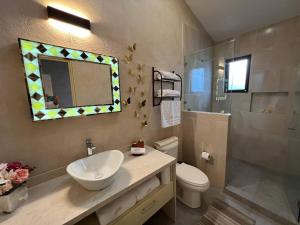 un bagno con lavandino, WC e specchio di Aida en ValQuirico a Santeagueda