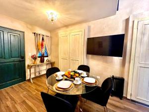 una sala da pranzo con tavolo, sedie e televisione di Aida en ValQuirico a Santeagueda