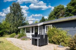 a house with a table and chairs in the yard at Family Friendly Home Close To Beach & Gilleleje in Gilleleje