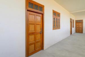 an empty room with a wooden door and a hallway at Hotel O SK in Sītāpur