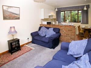 a living room with two blue couches and a table at Violets in Tonbridge