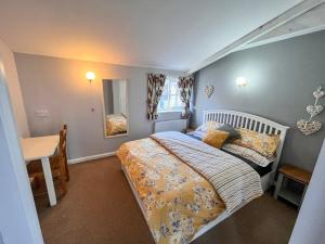 una camera da letto con un letto, un tavolo e una scrivania di Blueberry Cottage a Bedfield