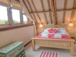 a bedroom with a bed with pink pillows on it at Henry's Barn - Ukc3168 in Walpole