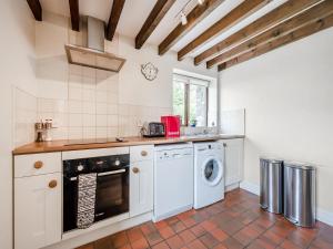 a kitchen with a washer and dryer at Rhyblid Fach in Myddfai