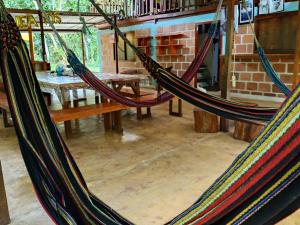 two hammocks hanging in a room with a table at Hostal Pakore Wera in Bahía Solano +2 photos