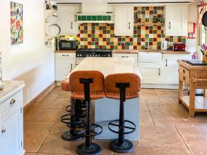 Una cocina con gabinetes blancos y encimera. en Beer Farm, en Stawley