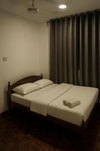 a bedroom with a bed with two towels on it at Country heights Homestay in Donggongon