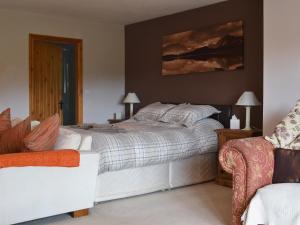 a bedroom with a bed and a couch at Glanrafon Isaf in Llanwnda