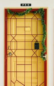 a yellow door with a wreath on it at Country heights Homestay in Donggongon