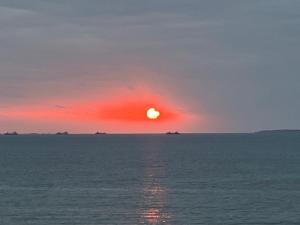 a sunset over the ocean with ships in the distance at Sunrise terrace kintown in Kin
