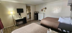 a hotel room with two beds and a television at Sundown Lodge in Eureka