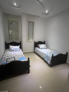 a bedroom with two beds in a room at Résidence Al Massira Fnideq in Fnidek