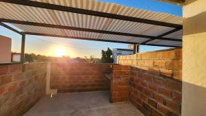 een terras met luifel op een bakstenen muur bij Apartamento 5 in Crespo