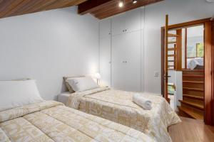 a bedroom with two beds and a stair case at Casa Sonnendorf 4 dorm Centro by Achei Gramado in Gramado