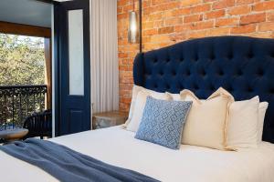 a bedroom with a large bed with a blue headboard at Casa Dianna - Timeless Terrace near CBD and Waterfront in Newcastle