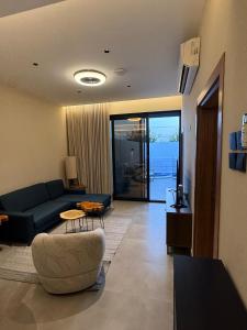 a living room with a blue couch and a table at JA Accom in Al ‘Ayn
