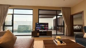 Una sala de estar con un sofá y un televisor. en JA Accom, en Al ‘Ayn