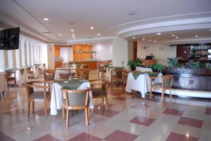 a restaurant with tables and chairs and a bar at Aranzazu Plaza Kristal Aguascalientes in Aguascalientes
