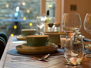 una mesa con platos y vasos en una mesa en Snowdrop Cottage, en Bulmer 27 fotos más