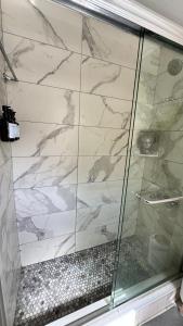 法洛克威Serenity Room JFK的浴室里有玻璃门的淋浴间