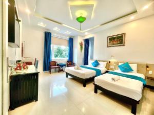 a hotel room with two beds and a living room at Flame Flowers Homestay in Hoi An +96 photos