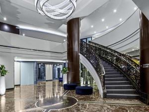 阿德莱德培泊维莫斯酒店的大厅里有螺旋楼梯和蓝色凳子