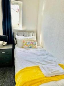 a bedroom with a bed with a yellow blanket at Blackpool Pleasure Beach whole Holiday Home! in Blackpool