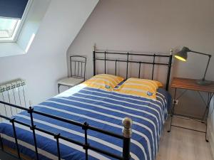 a bedroom with a bed with blue and yellow stripes at Holiday Home in France near Sandy Beaches in Guissény