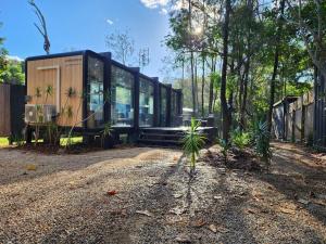 a glass house in the middle of a forest at Coastal Bliss New Brighton Eco Pod 50m to Beach in New Brighton