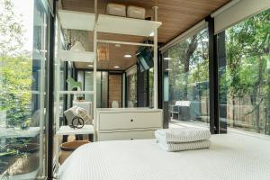 a bedroom with a bed and a large window at Coastal Bliss New Brighton Eco Pod 50m to Beach in New Brighton