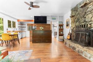 a living room with a fireplace and a dining room at Redwood Cabin with Hot Tub Canyon View and Dogs OK in Guerneville