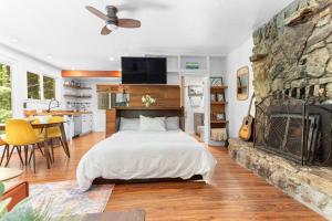 a bedroom with a bed and a stone wall at Redwood Cabin with Hot Tub Canyon View and Dogs OK in Guerneville +25 photos