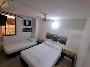 a small room with two beds and a window at Apartaestudio en el Rodadero junto al mar in Gaira