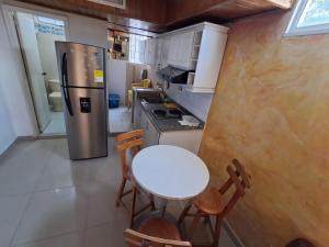 a small kitchen with a table and a refrigerator at Apartaestudio en el Rodadero junto al mar in Gaira
