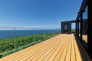 a wooden deck with the ocean in the background at Yunagi 夕凪プライベートサウナ付ヴィラオーシャンフロントの絶景宿 夕日とサウナを満喫海と夕日に包まれる贅沢空間 in Mōrai