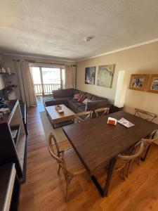 una sala de estar con una mesa y un sofá en HOM I SKI IN OUT Edif Valle del Sol 3D3B y Jacuzzi VS307, en Lo Barnechea