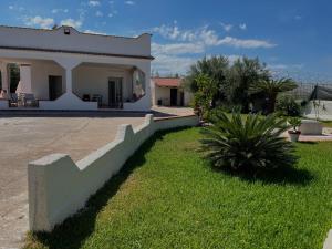 a large white house with a staircase in the yard at Villa Valentina casa vacanze fontane Bianche in Fontane Bianche