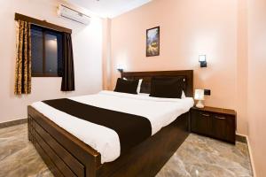 a bedroom with a large bed and a window at Hotel O M H Club And Resorts in Rānchī +38 photos