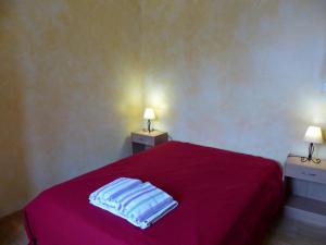 una camera con letto rosso e 2 comodini di Charmant gîte nature 2 chambres, rando GRP, près de Montluçon, cour commune - FR-1-489-418 a Saint-Palais